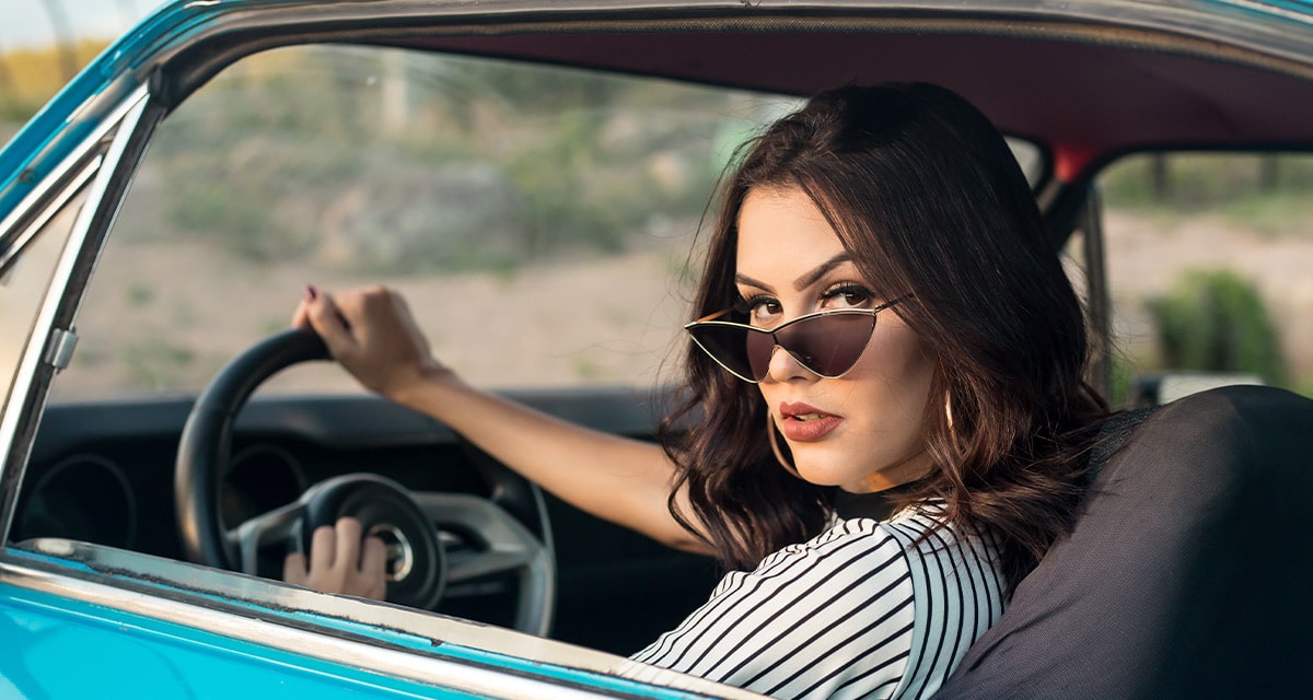 Women with sunglasses sitting in her car